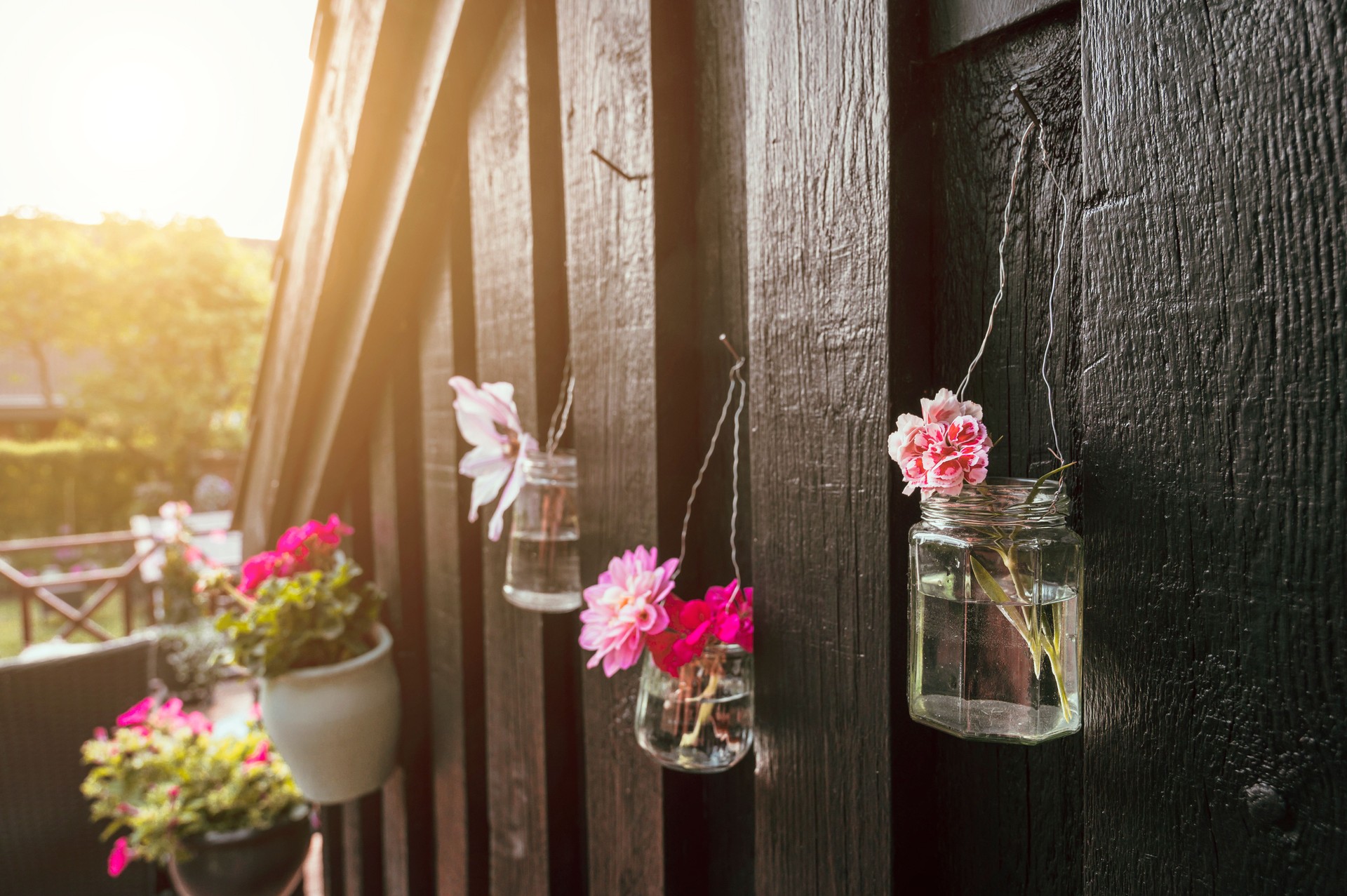 Do it yourself project with old jars upcycled into flower decorations outside